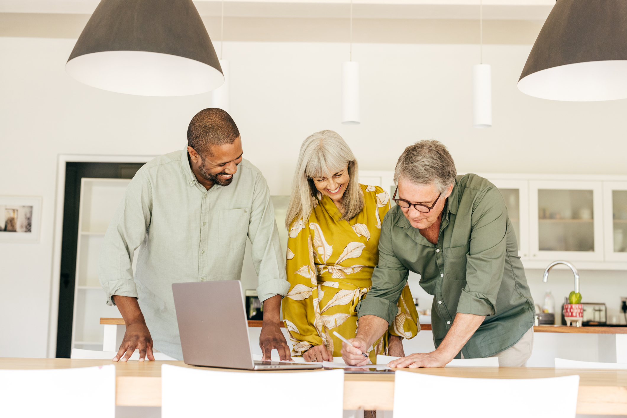 A senior couple meets with a real estate agent to review property options. They discuss how their growing net worth affects investment choices, ensuring their real estate plans align with changing financial goals and evolving needs