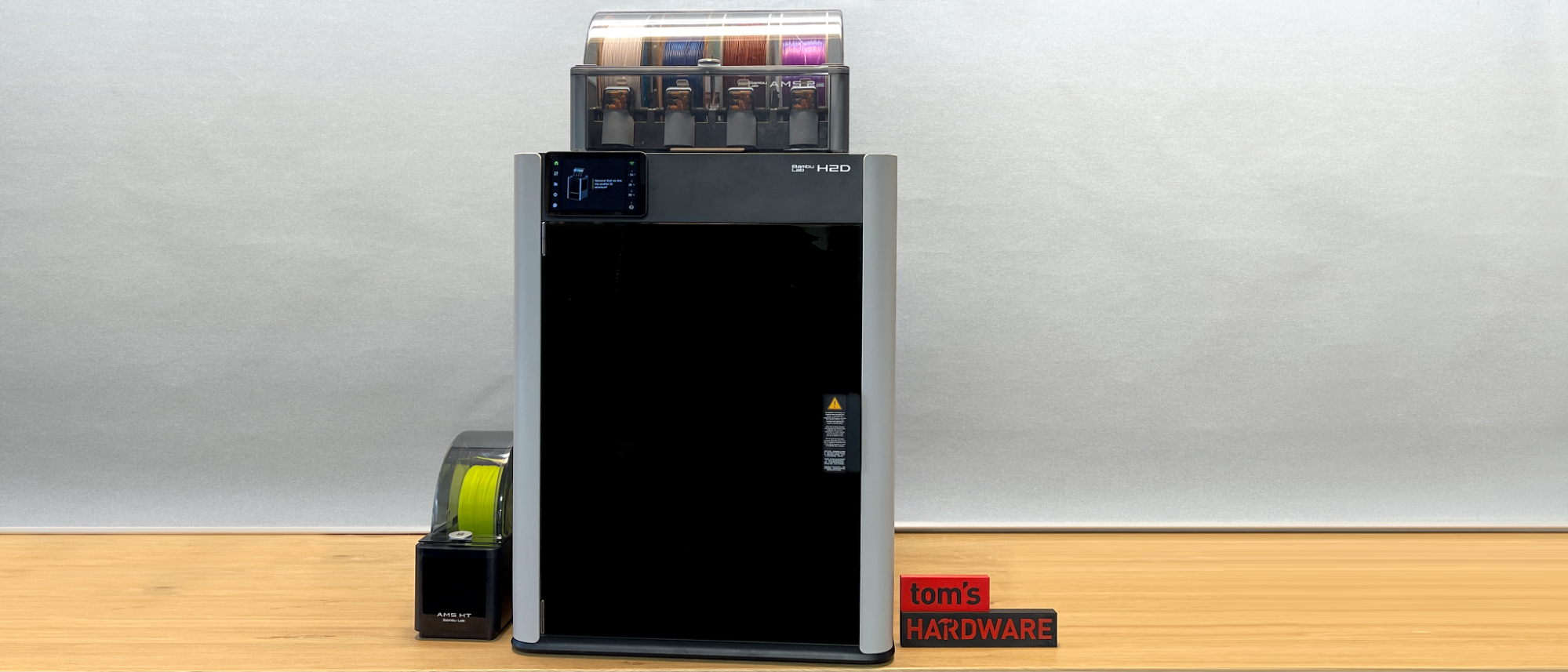 The Bambu Lab H2D with Automatic Material System (AMS) on workbench.