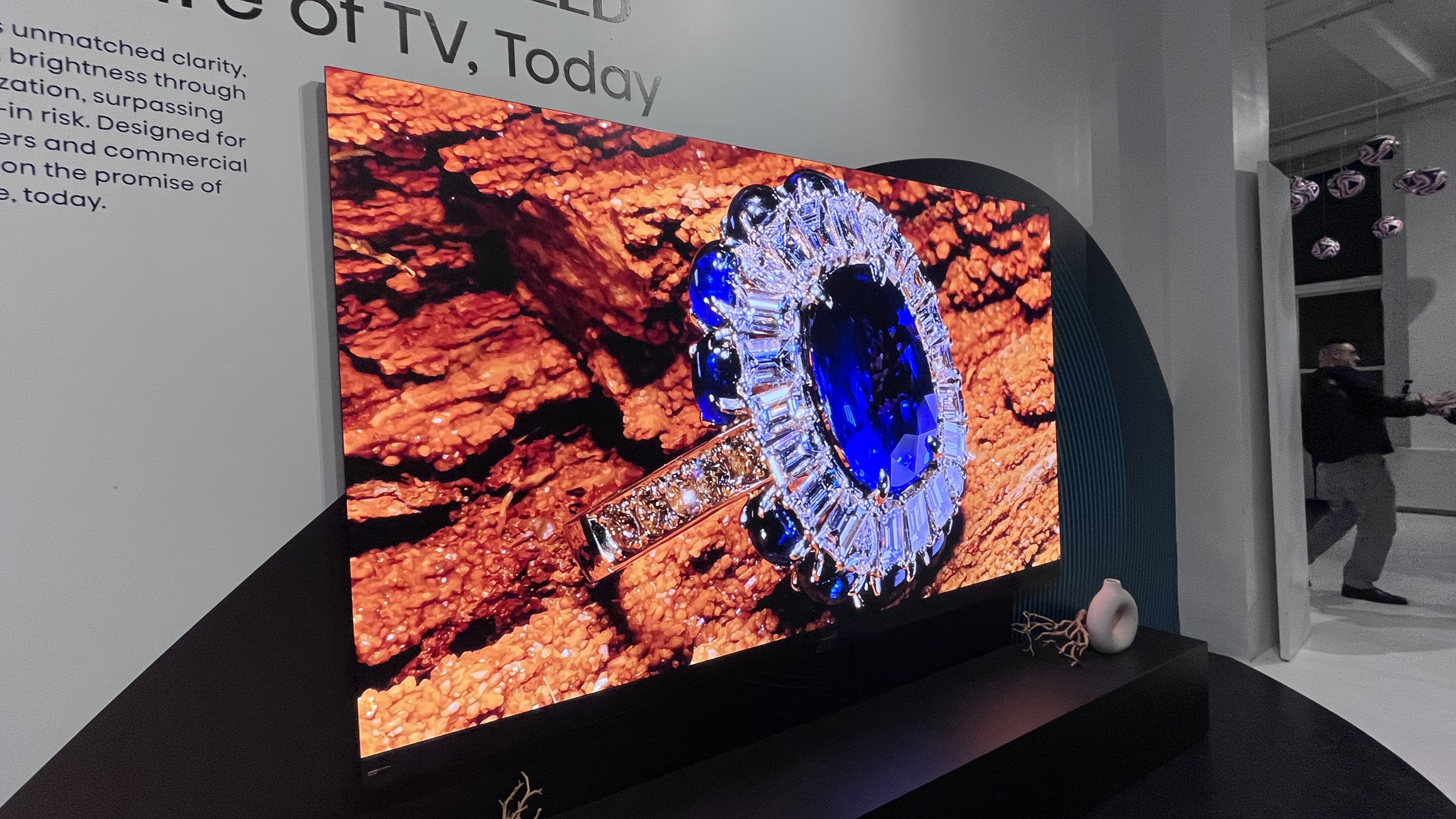 Hisense 136MX micro-LED TV showing image of jewels against wood background