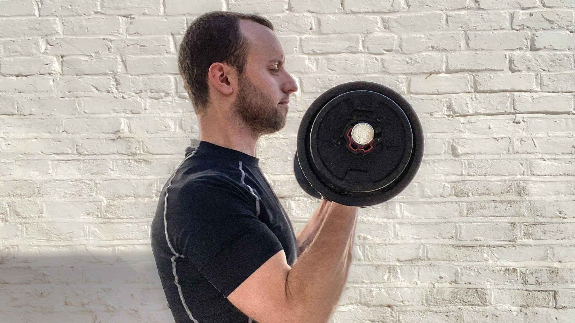 James Frew doing a biceps curl outside